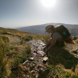 Recogiendo agua en una cantimplora en un chorro de agua del Maitena