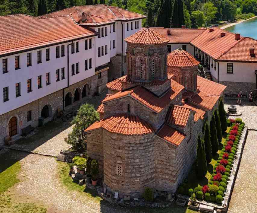 Vista aérea del complejo del Monasterio de San Naum con sus tejados de teja roja y jardines junto al lago Ohrid.