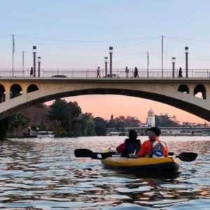 tour en kayak por el Guadalquivir con el puente de Los Remedios de fondo